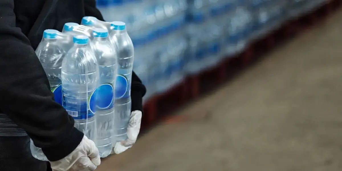woman-carrying-drinking-waters-with-gloved-hands-coronavirus-pandemic